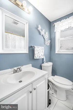 a bathroom with a sink a toilet and a window