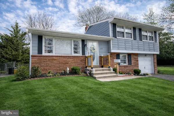 a front view of a house with a yard and trees
