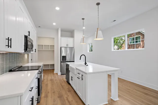 a kitchen with granite countertop a sink a stove and cabinets