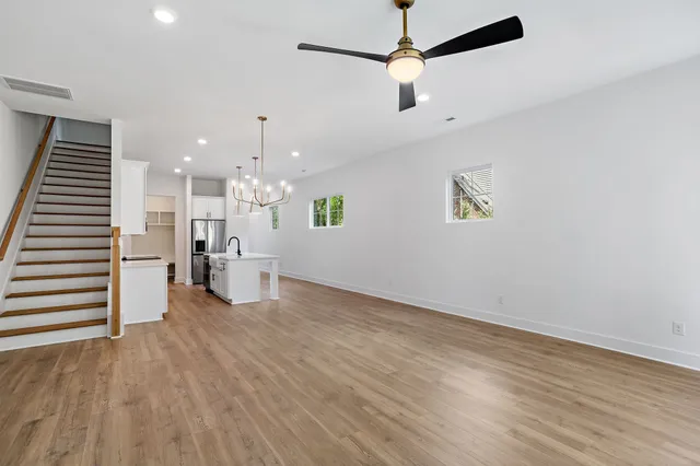 a view of a hallway with wooden floor and a bathroom