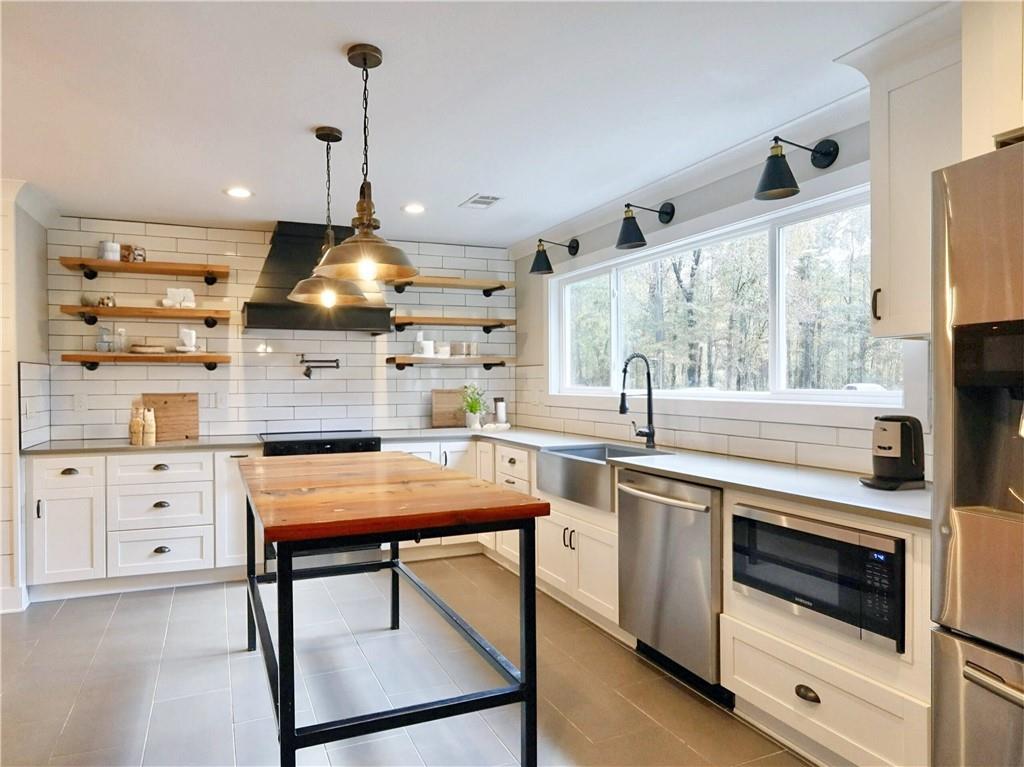 4925 Cook Road Southwest Stockbridge, GA 30281 - Photo 11 of 32 a kitchen with stainless steel appliances a stove a sink and a refrigerator