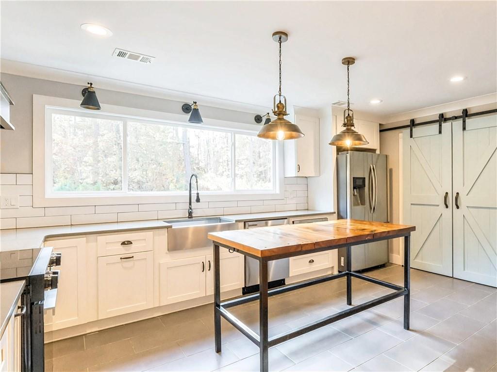 4925 Cook Road Southwest Stockbridge, GA 30281 - Photo 9 of 32 a kitchen with stainless steel appliances granite countertop a stove a sink and a refrigerator