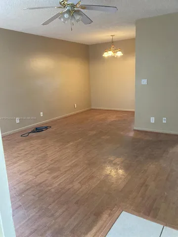 an empty room with a fan & a ceiling fan