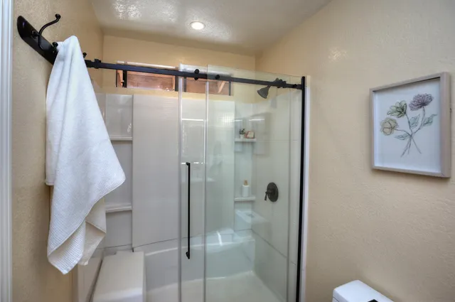 a bathroom with a shower and a glass door