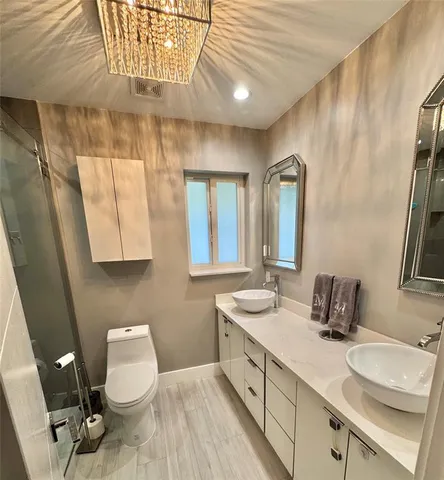 a bathroom with a double vanity sink toilet and mirror