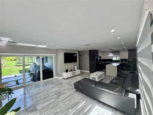 a living room with furniture flat screen tv and a large window