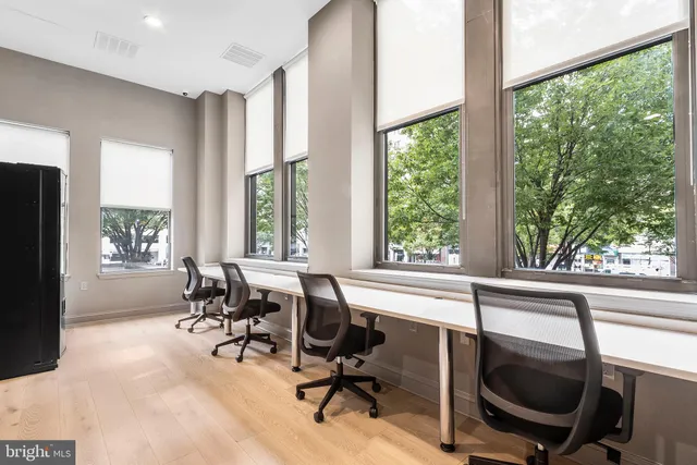 a view of a workspace with furniture and a window