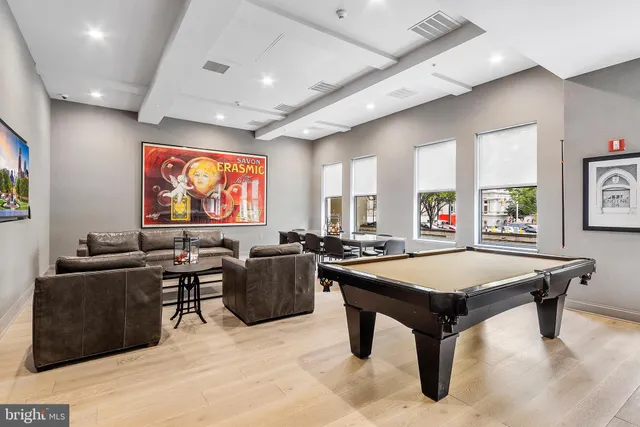 a kitchen with stainless steel appliances granite countertop a table chairs sink and stove