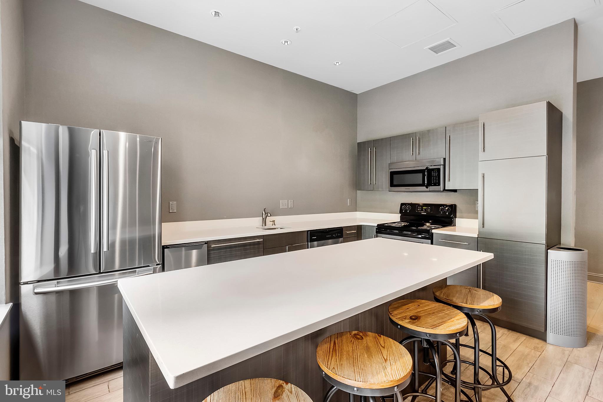 7 North Calvert Street, Unit 1BR Baltimore, MD 21202 - Photo 22 of 32 a kitchen with stainless steel appliances a refrigerator and a stove top oven