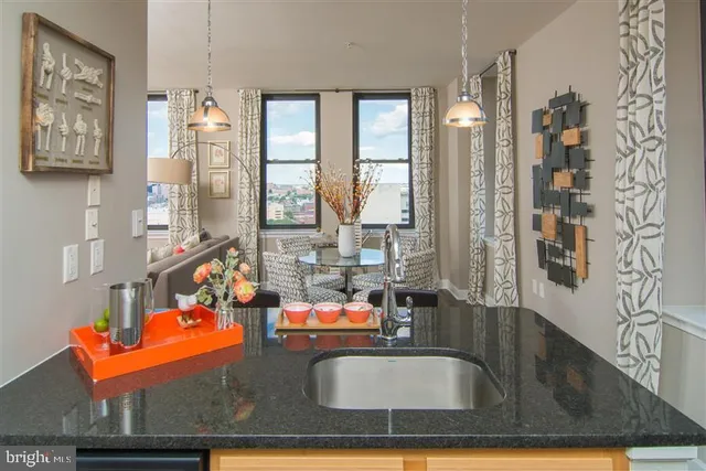 a kitchen with stainless steel appliances granite countertop a table and chairs