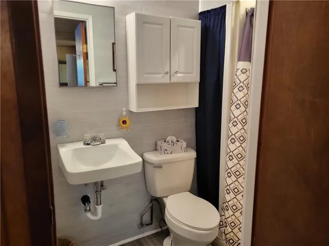 a bathroom with a toilet sink and mirror