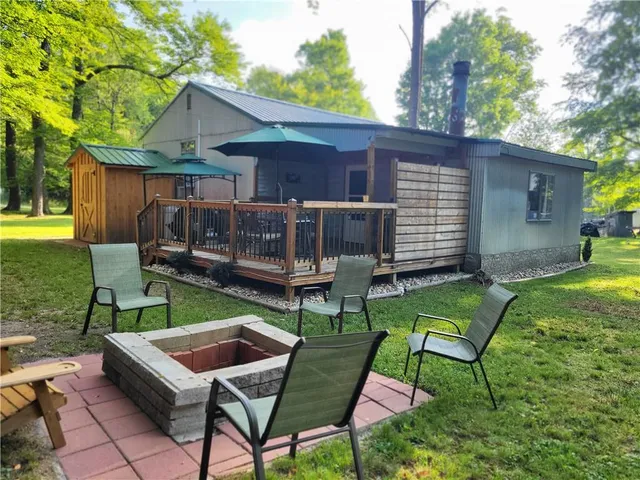 a view of a backyard with table and chairs with wooden fence and plants