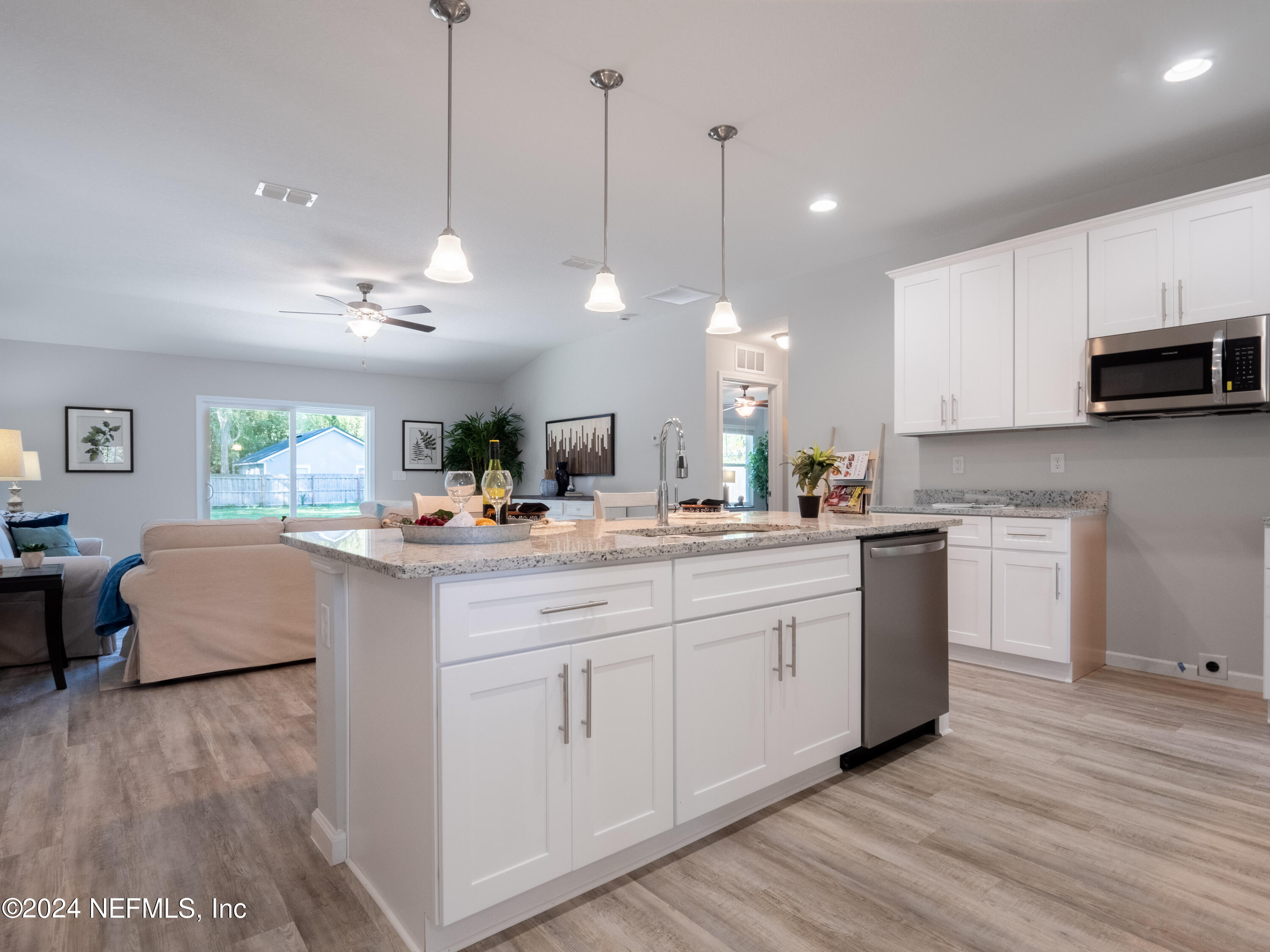4011 Spring Glen Road Jacksonville, FL 32207 - Photo 15 of 38 a kitchen with kitchen island granite countertop a sink a counter space appliances and cabinets