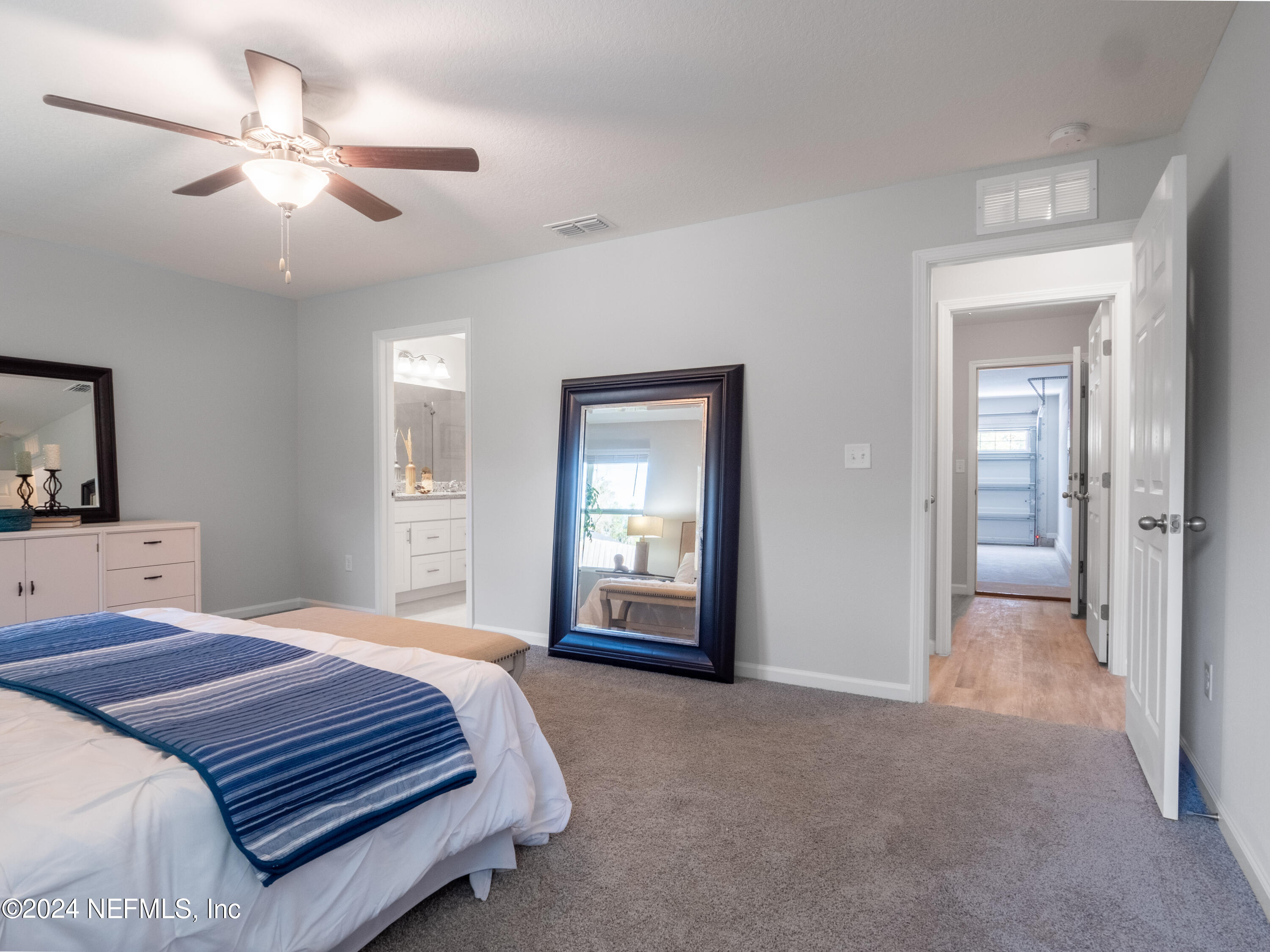 4011 Spring Glen Road Jacksonville, FL 32207 - Photo 25 of 38 a spacious bedroom with a bed and a chandelier