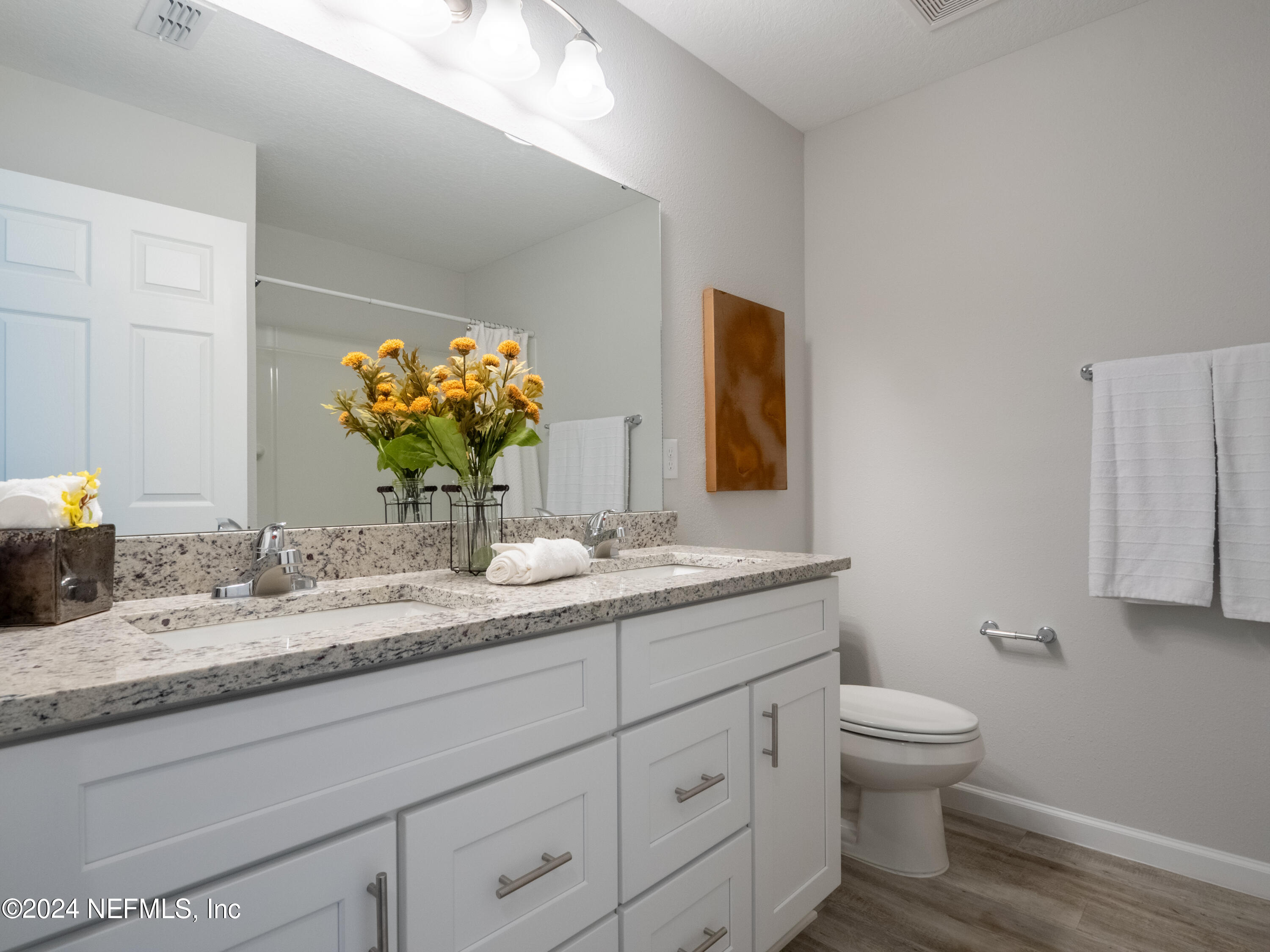 4011 Spring Glen Road Jacksonville, FL 32207 - Photo 30 of 38 a bathroom with a granite countertop toilet sink and mirror