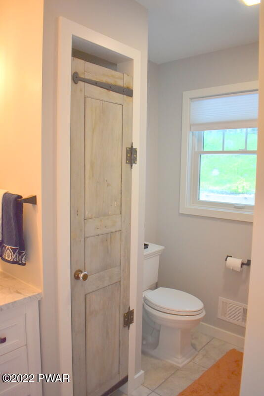 549 Finn Swamp Road Lakeville, PA 18438 - Photo 15 of 35 a white toilet sitting next to a bathroom sink and vanity