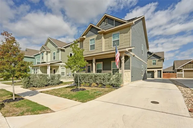 a front view of a house with yard and trees around