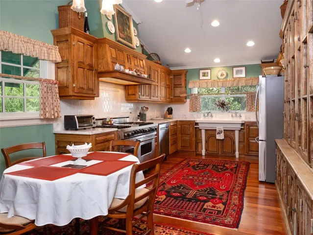 a kitchen with stainless steel appliances granite countertop a stove a sink and a refrigerator