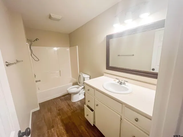 a bathroom with a sink a toilet and a large mirror