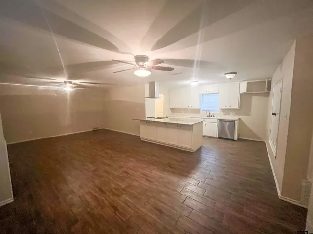 a view of a kitchen with a sink a refrigerator wooden floor and a window