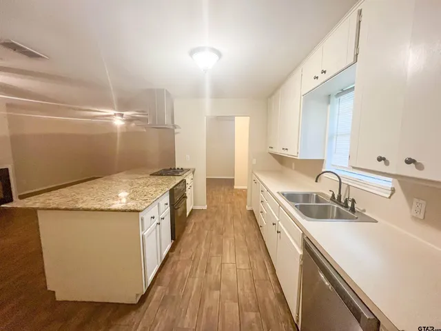 a kitchen with a sink and wooden floor