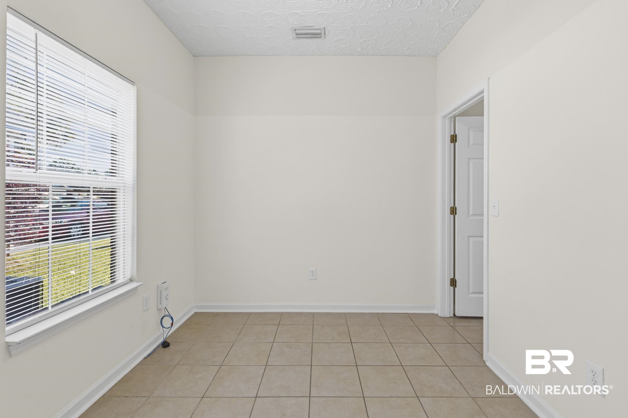 1153 Sloane Cove Foley, AL 36535 - Photo 10 of 25 Spare room featuring light tile patterned floors and a textured ceiling