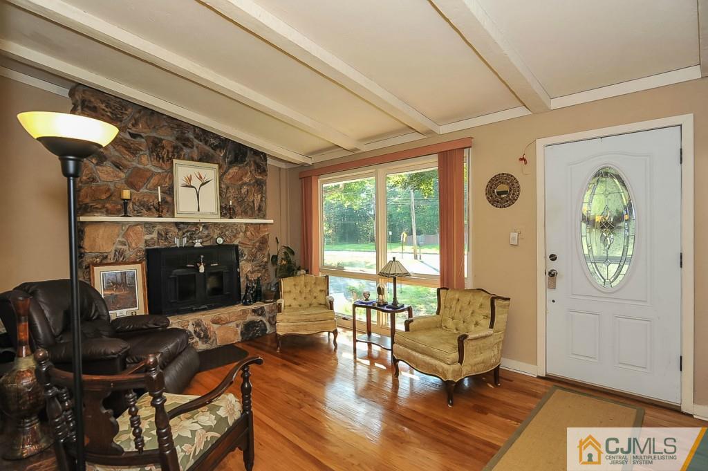 36 Middlesex Road Matawan, NJ 07747 - Photo 2 of 14 a living room with furniture a rug a fireplace and a floor to ceiling window