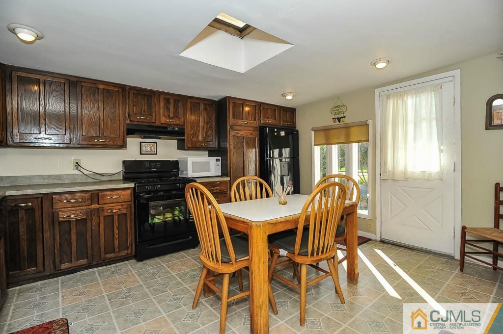 36 Middlesex Road Matawan, NJ 07747 - Photo 5 of 14 a kitchen with stainless steel appliances wooden cabinets dining table and chairs