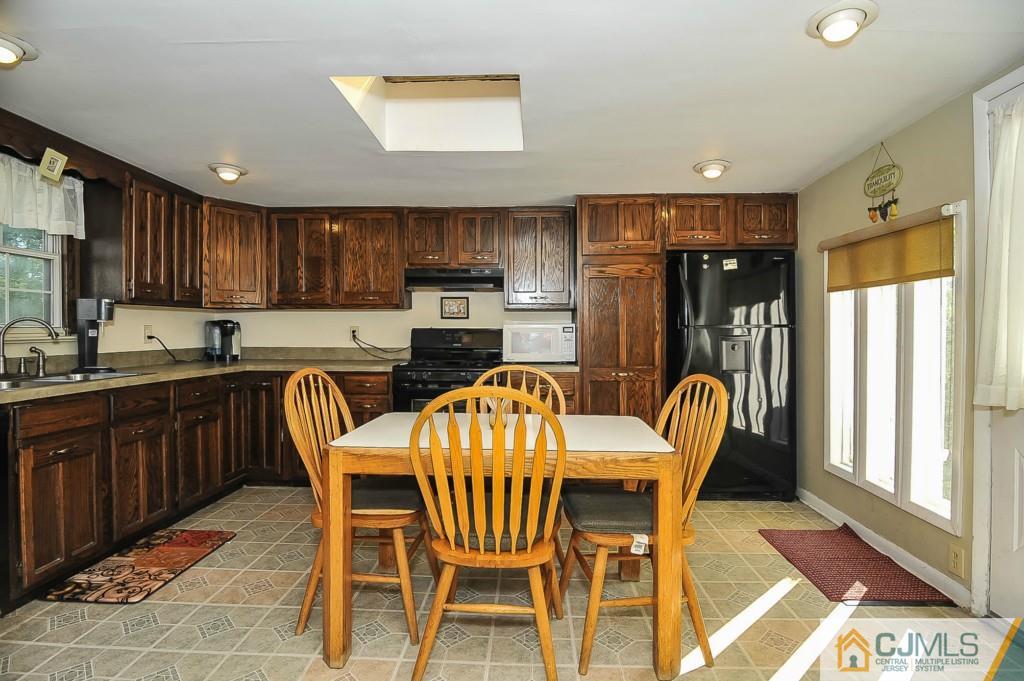 36 Middlesex Road Matawan, NJ 07747 - Photo 6 of 14 a kitchen with a dining table chairs and refrigerator