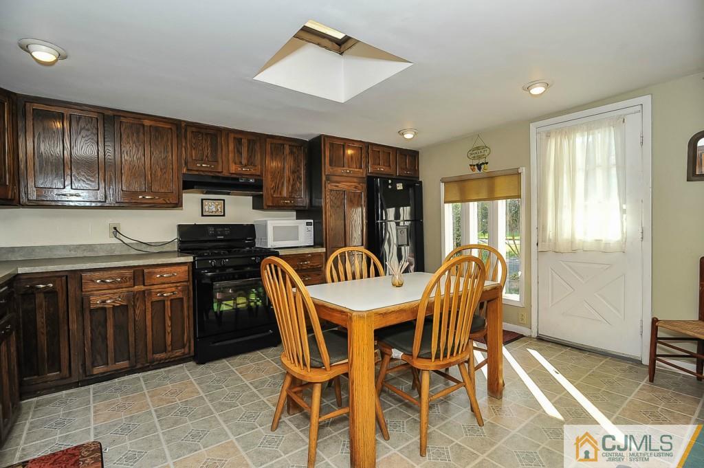 36 Middlesex Road Matawan, NJ 07747 - Photo 7 of 14 a kitchen with stainless steel appliances wooden cabinets dining table and chairs