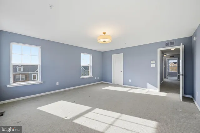 a view of an empty room with window and bathroom