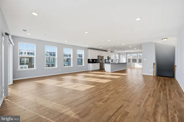 a view of a living room a kitchen with a sink and cabinets