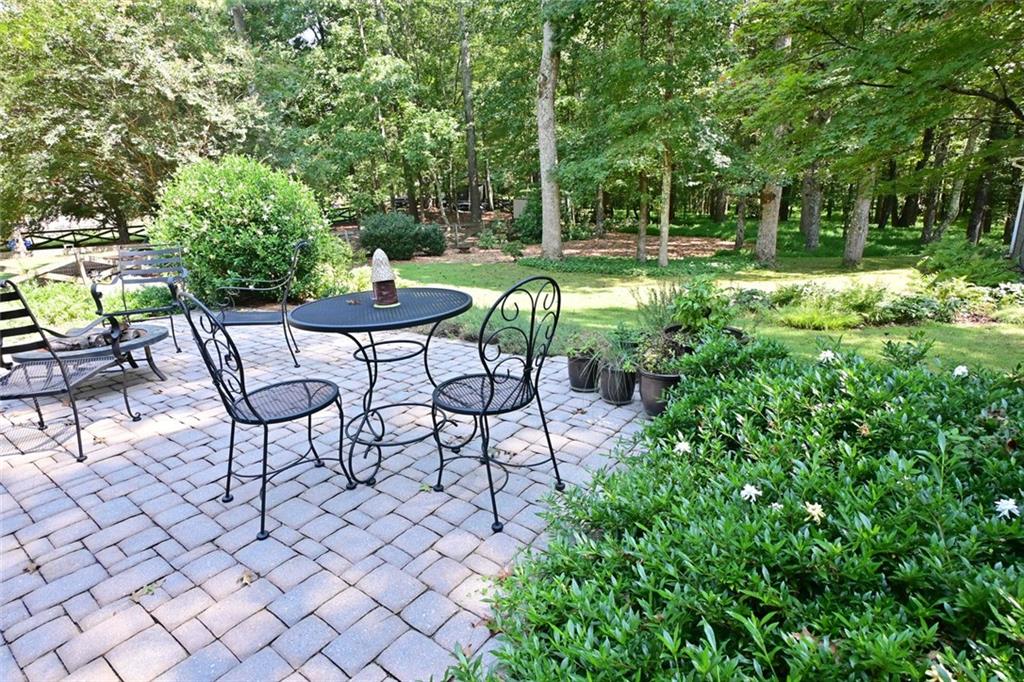 4865 Settles Point Road Suwanee, GA 30024 - Photo 1 of 25 a backyard of a house with table and chairs