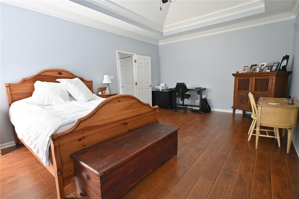 4865 Settles Point Road Suwanee, GA 30024 - Photo 13 of 25 a bedroom with bed and a chair