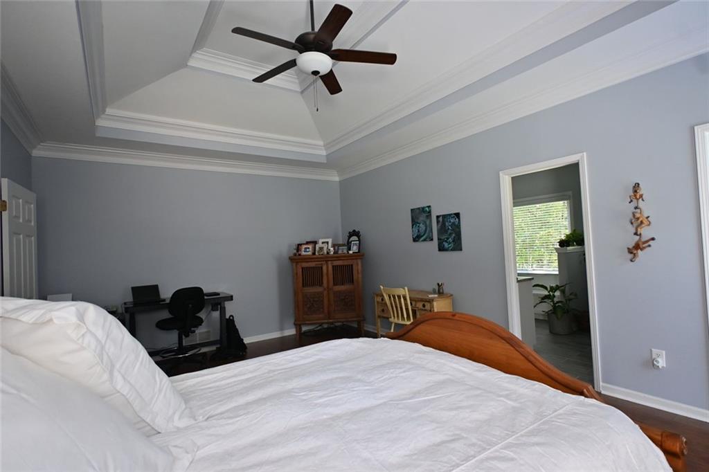 4865 Settles Point Road Suwanee, GA 30024 - Photo 14 of 25 a bedroom with a bed and a chandelier
