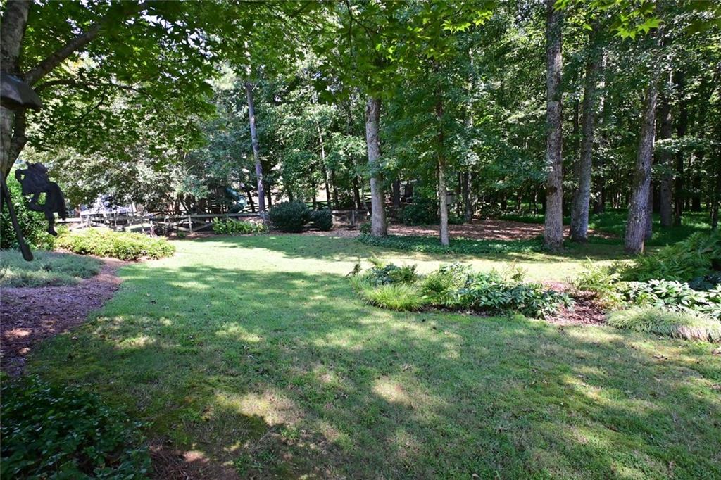 4865 Settles Point Road Suwanee, GA 30024 - Photo 22 of 25 a view of a backyard with large trees
