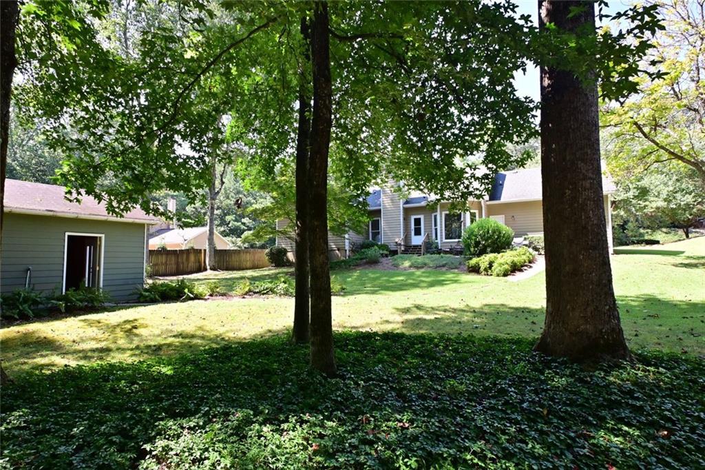 4865 Settles Point Road Suwanee, GA 30024 - Photo 23 of 25 a backyard of a house with table and chairs