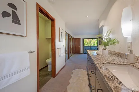 a bathroom with a granite countertop sink a mirror and a shower