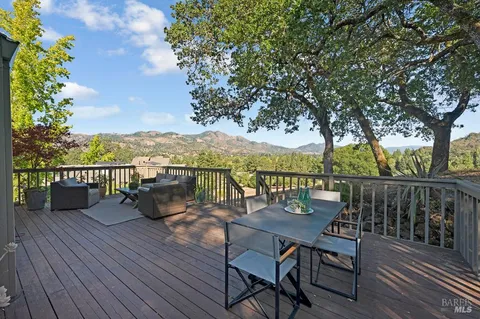 a view of a balcony with wooden floor and seating space