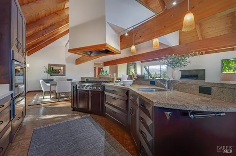 a kitchen with stainless steel appliances granite countertop a sink a stove and a wooden floors