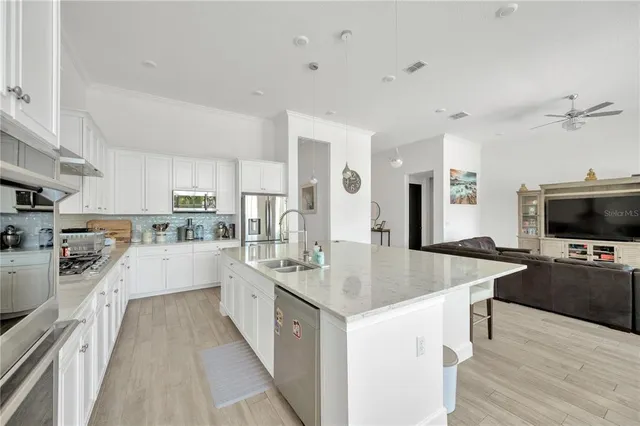 a large kitchen with kitchen island a sink counter space and stainless steel appliances