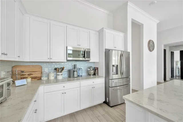 a kitchen with stainless steel appliances granite countertop a refrigerator sink and stove