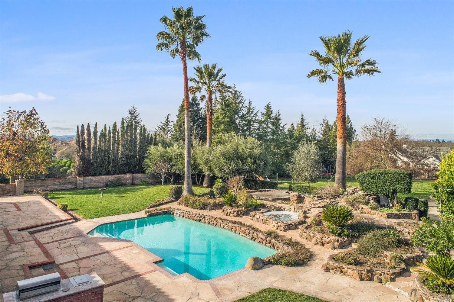 a view of a swimming pool with a patio and a yard