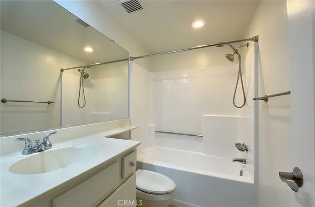a bathroom with a granite countertop sink a toilet and shower