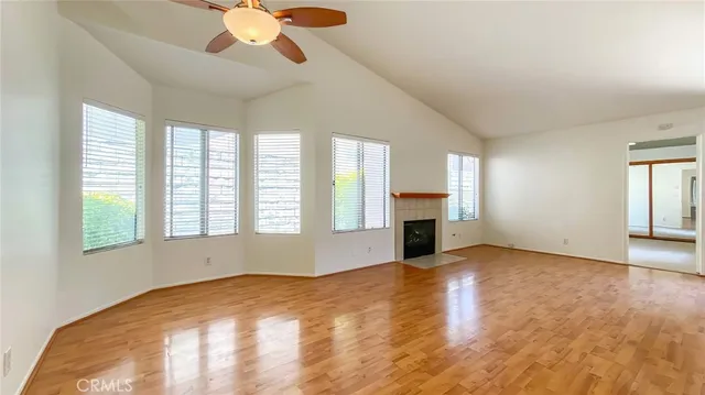 a view of an empty room with window and wooden floor
