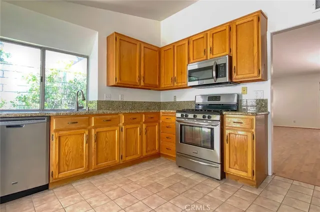 a kitchen with stainless steel appliances granite countertop a stove a sink and a refrigerator