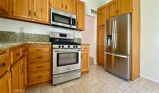 a kitchen with stainless steel appliances granite countertop a refrigerator stove and microwave