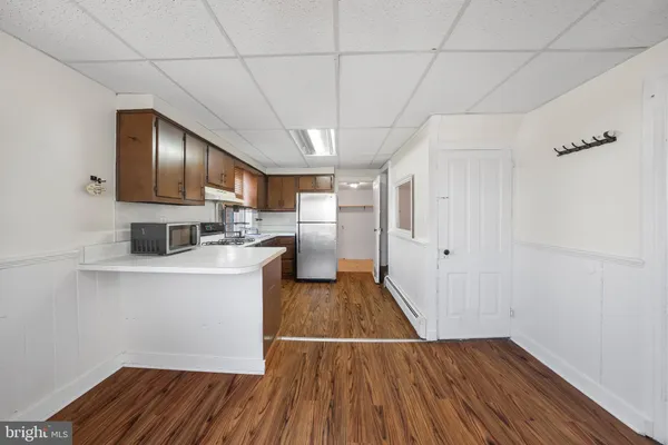 a kitchen with wooden floors and refrigerator