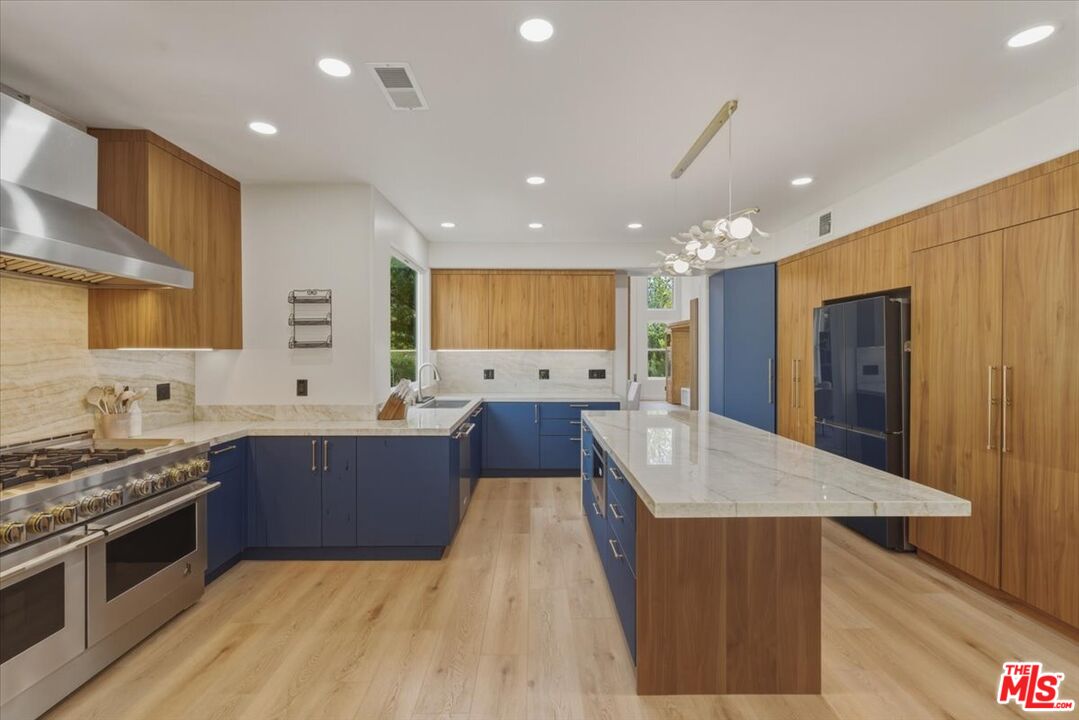 3891 Marks Road Agoura Hills, CA 91301 - Photo 16 of 52 a large kitchen with stainless steel appliances a large counter top a stove a chimney a sink and a refrigerator