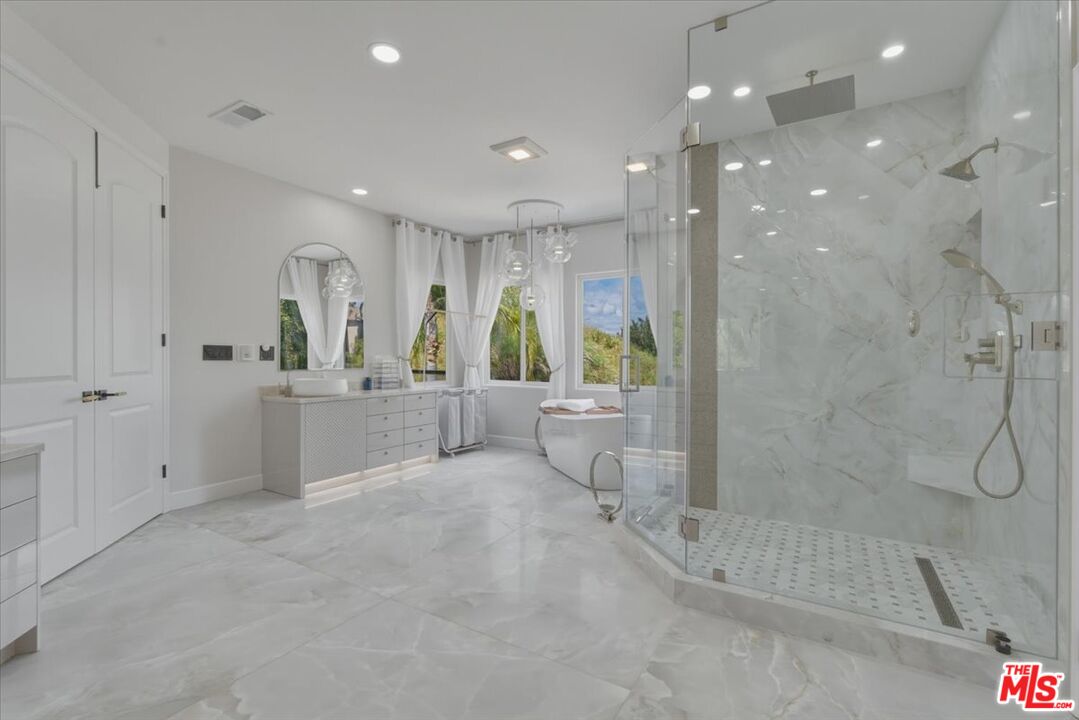 3891 Marks Road Agoura Hills, CA 91301 - Photo 34 of 52 a bathroom with a tub a sink a mirror and a shower